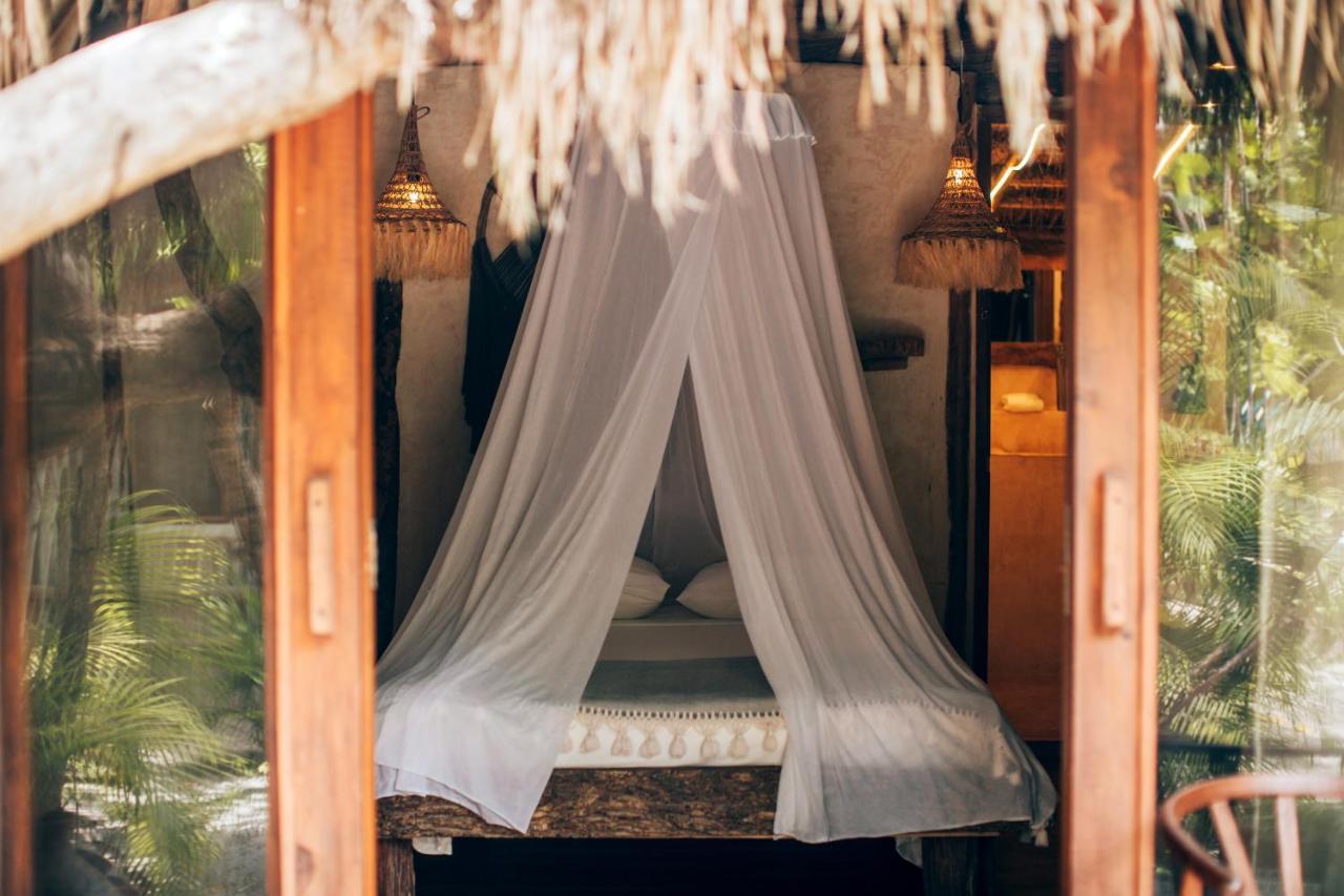 Ikal Tulum Hotel ภายนอก รูปภาพ A mosquito net over a bed